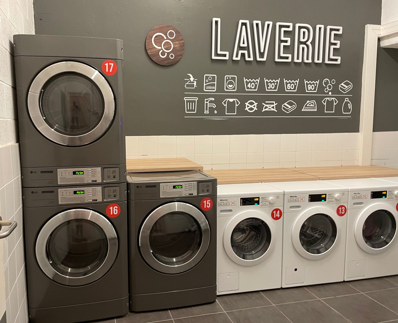 Laverie collective d’une résidence à Lille, avec lave-linge et séchoirs superposés